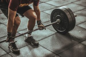 man lifting a barbell in the gym