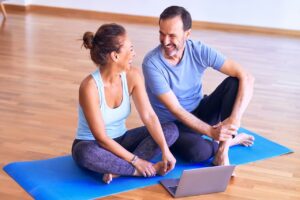 a man and woman talking sitting on a yoga mat