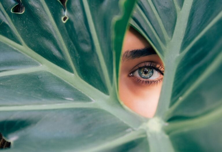 close up of face behind a leaf