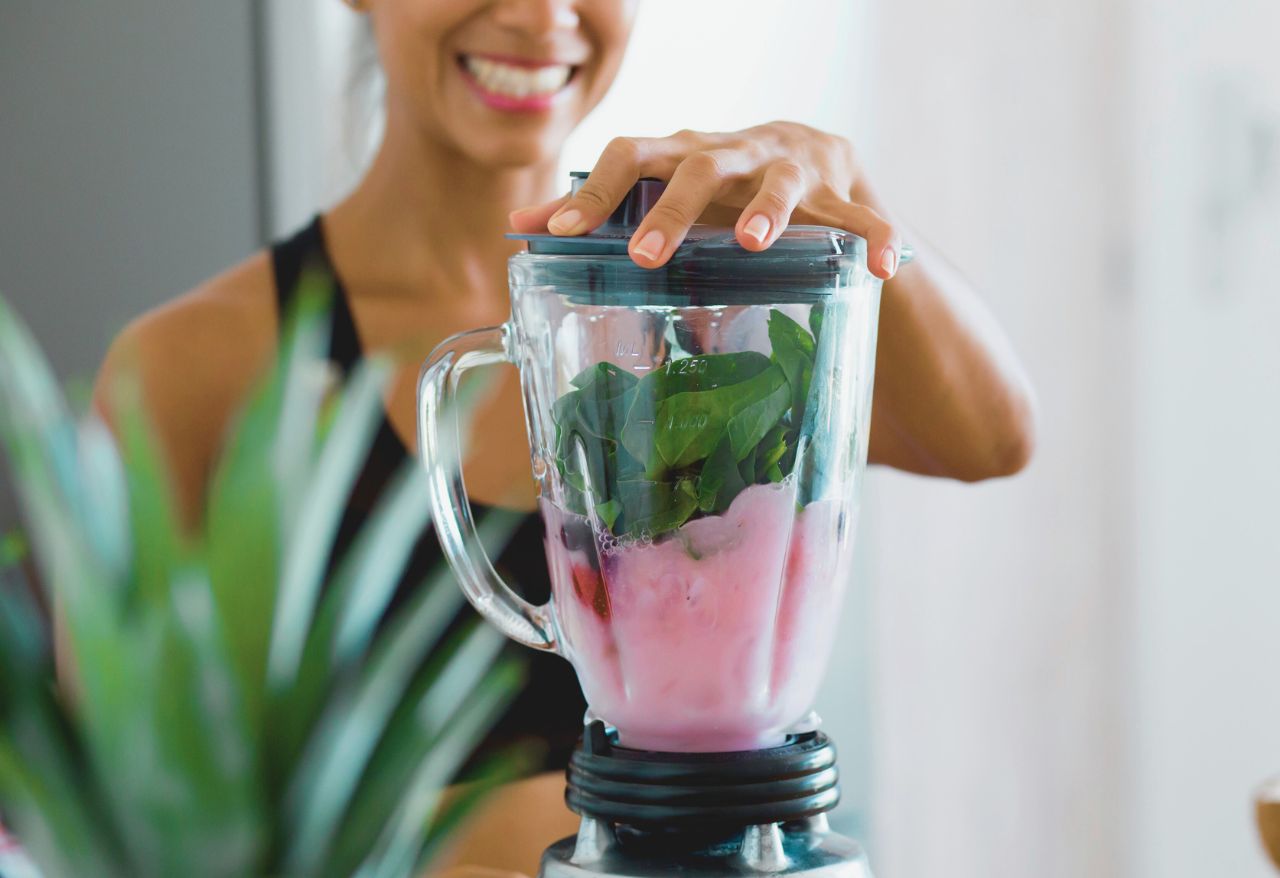 woman making a smoothie in the blender
